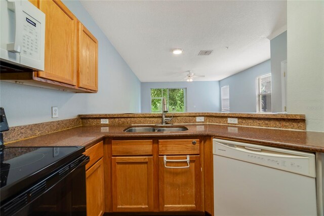 kitchen featuring kitchen peninsula, white appliances, sink, and ceiling fan