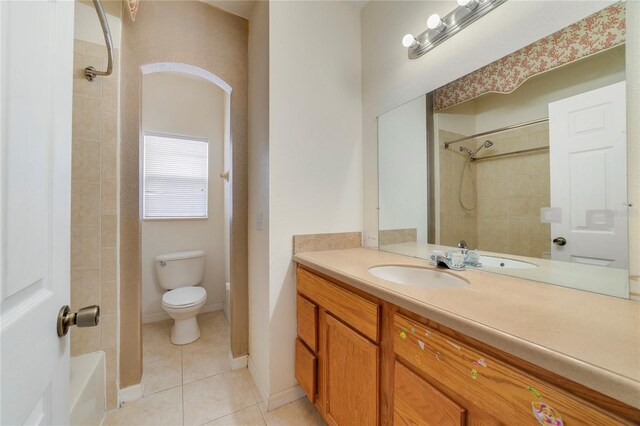 full bathroom featuring tile patterned floors, vanity, tiled shower / bath combo, and toilet