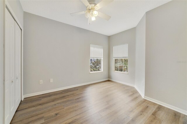 unfurnished bedroom featuring ceiling fan, hardwood / wood-style floors, and a closet