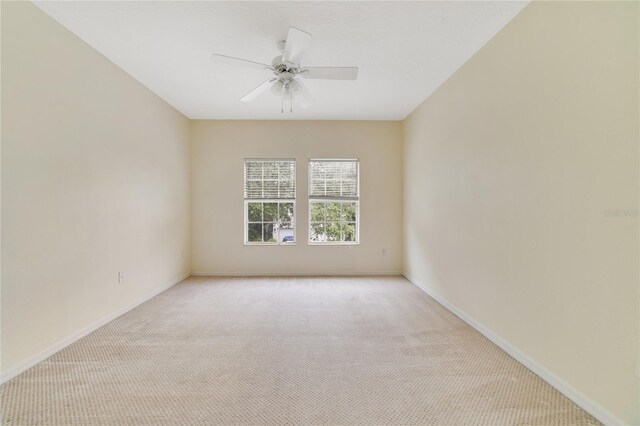 carpeted spare room featuring ceiling fan