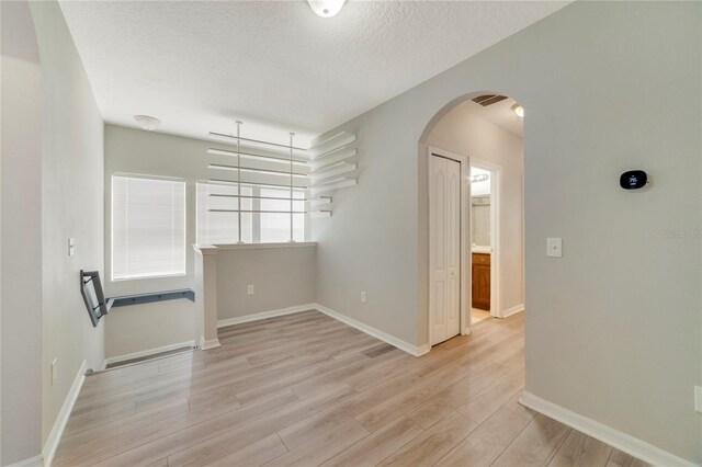 interior space featuring a textured ceiling and light hardwood / wood-style flooring