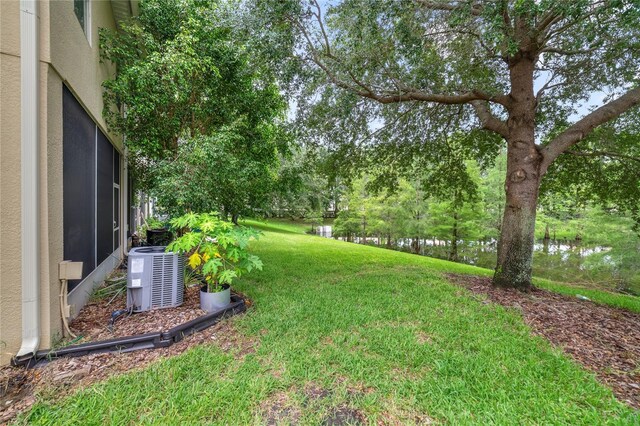 view of yard featuring central AC unit and a water view