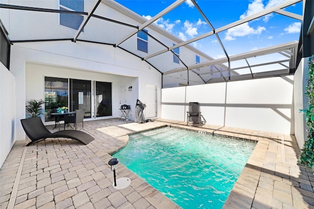 view of pool with glass enclosure and a patio