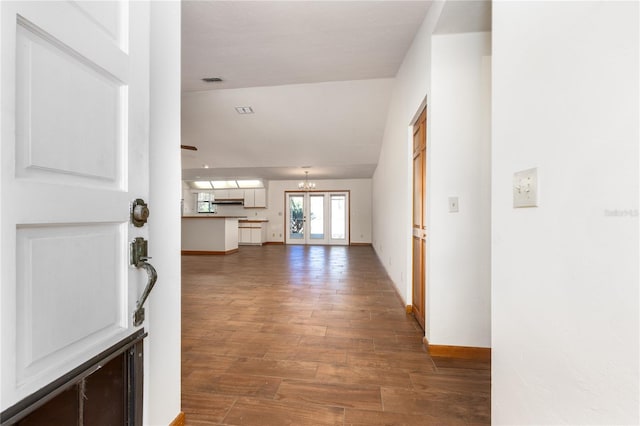 foyer with an inviting chandelier, french doors, and dark hardwood / wood-style flooring