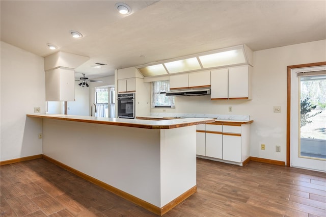 kitchen featuring kitchen peninsula, ceiling fan, white cabinetry, and hardwood / wood-style flooring