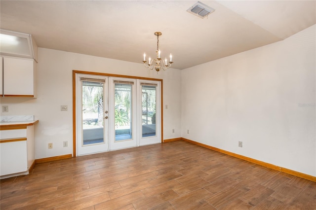 empty room featuring light hardwood / wood-style floors and a chandelier