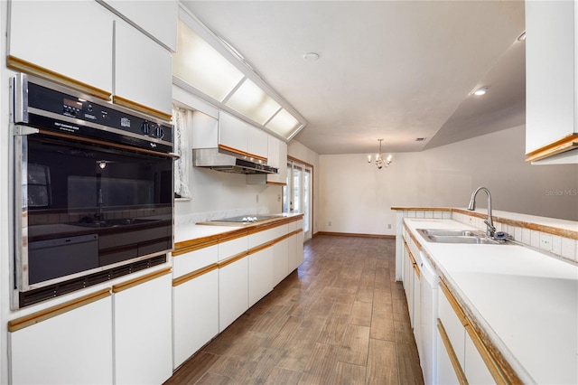 kitchen with a notable chandelier, hardwood / wood-style floors, white cabinetry, hanging light fixtures, and sink