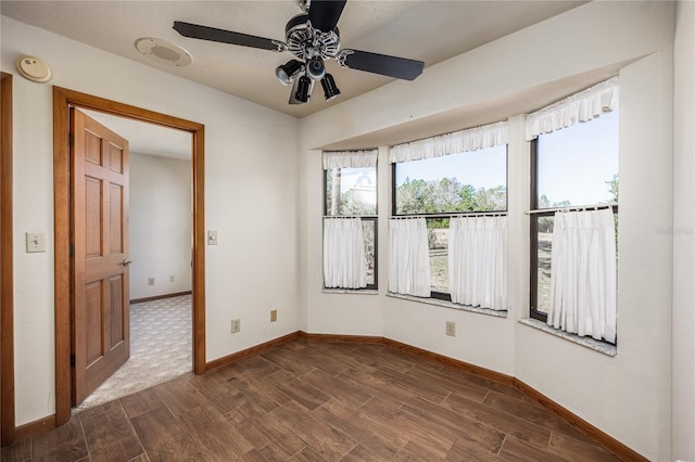 unfurnished room featuring ceiling fan and dark hardwood / wood-style flooring