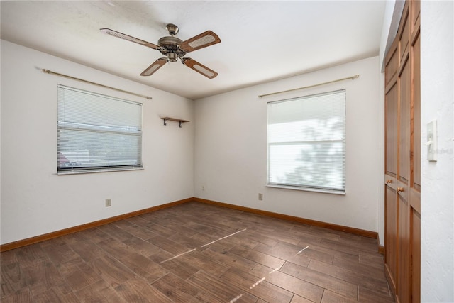 empty room with ceiling fan and dark hardwood / wood-style flooring