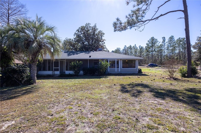 back of property with a yard and a sunroom