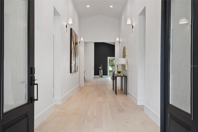 hall featuring light hardwood / wood-style flooring and vaulted ceiling