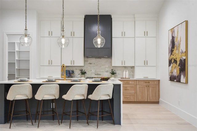 kitchen with white cabinetry and a kitchen island with sink