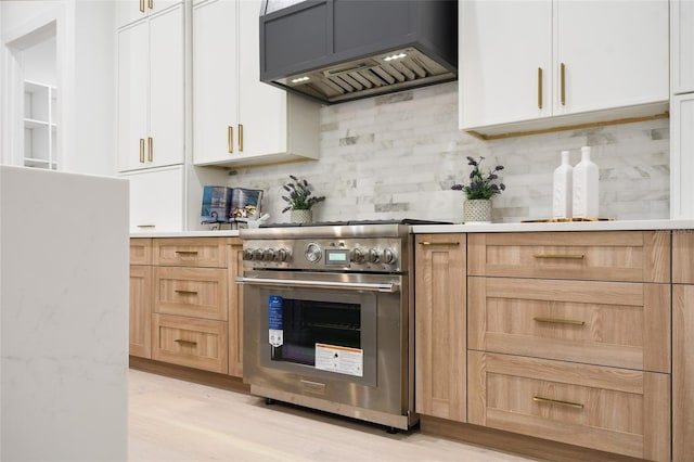 kitchen featuring stainless steel range, white cabinets, light hardwood / wood-style floors, and custom exhaust hood