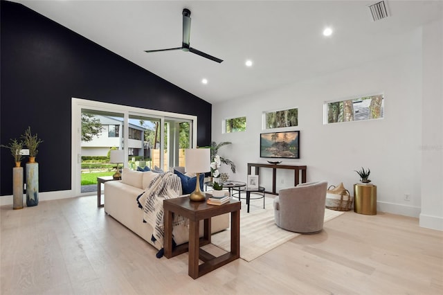 living room featuring ceiling fan, light hardwood / wood-style floors, and high vaulted ceiling