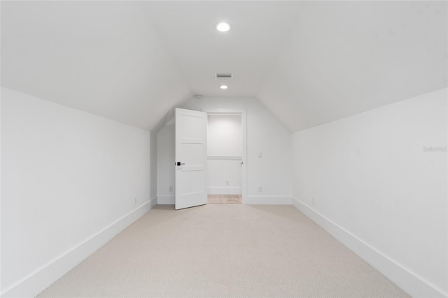 additional living space with light colored carpet and lofted ceiling