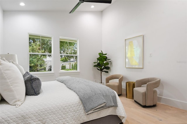 bedroom with ceiling fan, lofted ceiling, and light hardwood / wood-style flooring