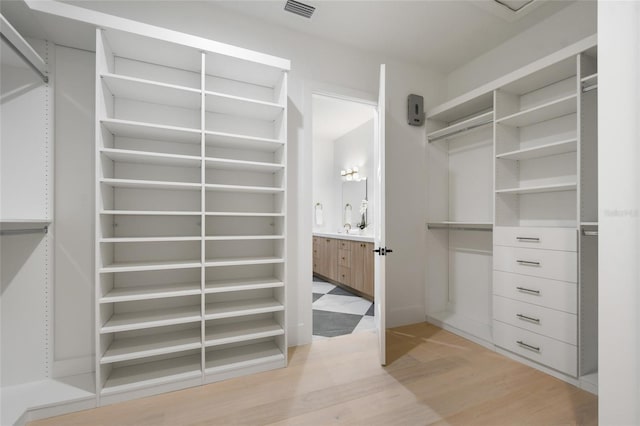 spacious closet with light hardwood / wood-style floors