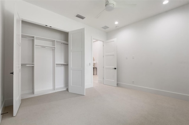 unfurnished bedroom featuring ceiling fan, light colored carpet, and a closet