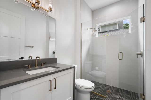 bathroom with tile patterned floors, a shower with door, vanity, and toilet