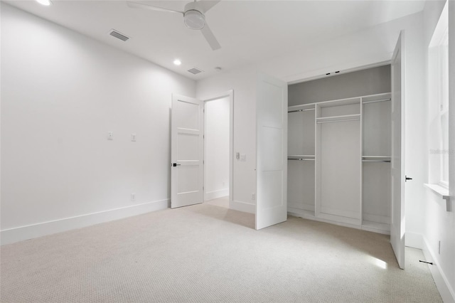 unfurnished bedroom with ceiling fan, a closet, and light carpet