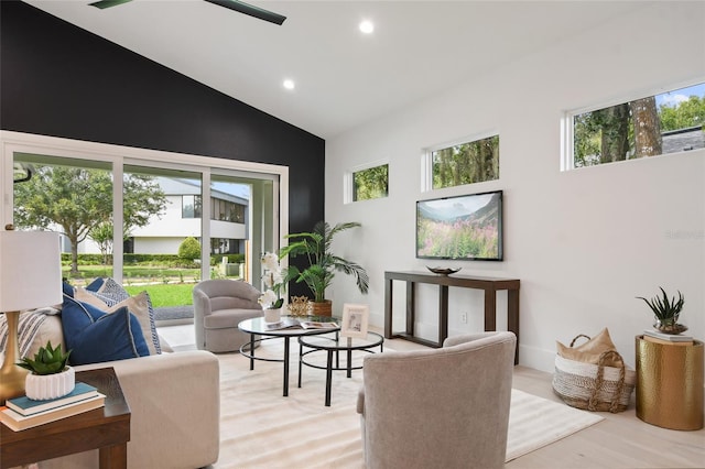 living room featuring a wealth of natural light, high vaulted ceiling, and light wood-type flooring