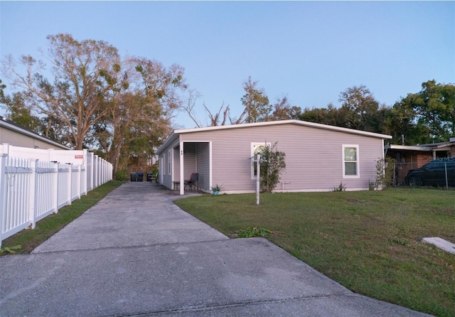 rear view of property featuring a carport and a yard