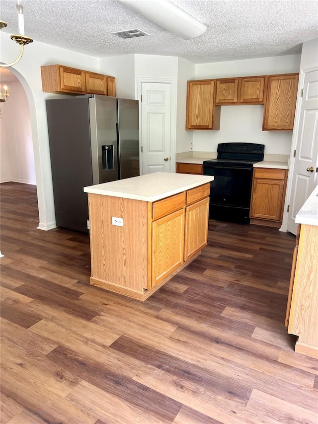 kitchen with dark wood-type flooring, a center island, black electric range oven, and stainless steel fridge with ice dispenser