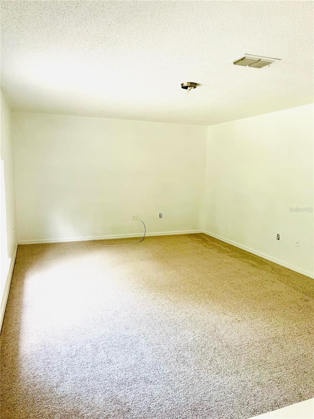 carpeted spare room with a textured ceiling
