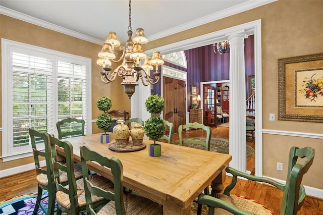 dining area featuring an inviting chandelier, dark hardwood / wood-style flooring, crown molding, and decorative columns