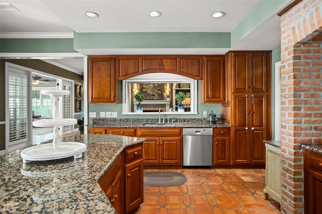 kitchen featuring dishwasher, brick wall, crown molding, dark stone countertops, and sink