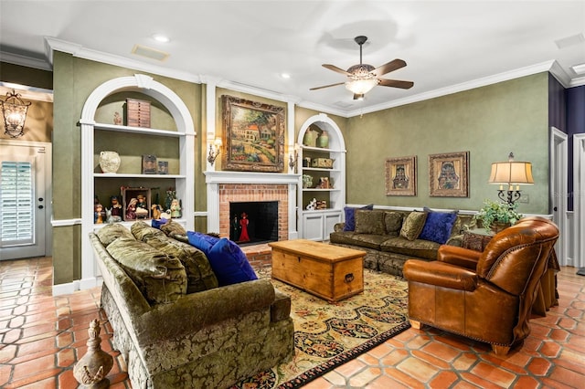 living room with ceiling fan, built in shelves, crown molding, tile floors, and a fireplace