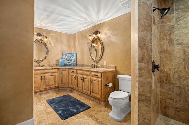 bathroom featuring double sink vanity, toilet, tile floors, and a tile shower