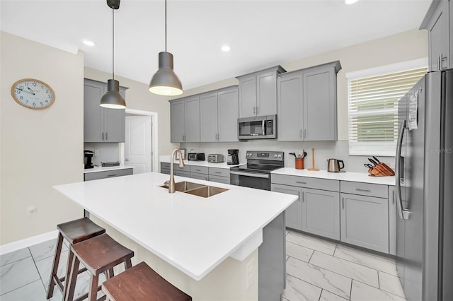 kitchen with a breakfast bar area, stainless steel appliances, light tile flooring, and gray cabinets