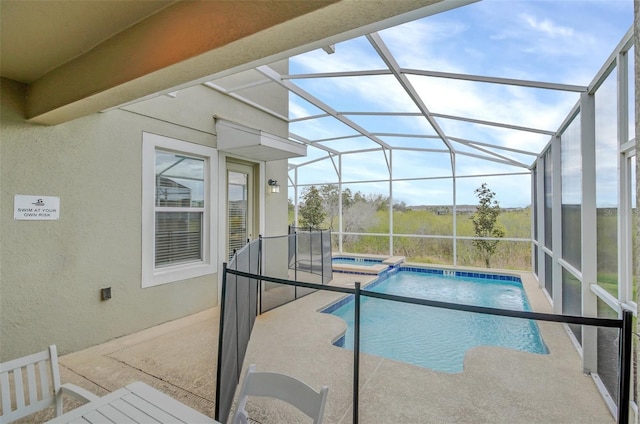 view of swimming pool with an in ground hot tub, glass enclosure, and a patio