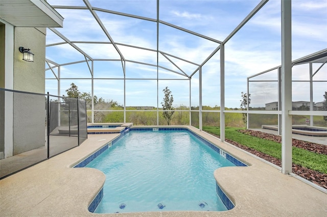 view of swimming pool with a patio, an in ground hot tub, and glass enclosure