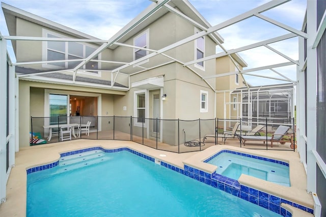 view of swimming pool with an in ground hot tub, glass enclosure, and a patio