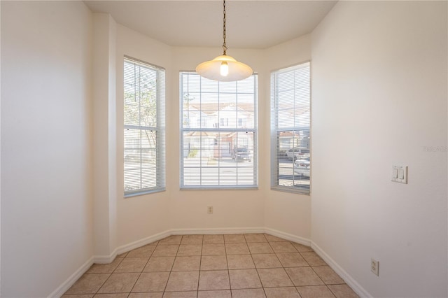 spare room featuring light tile patterned floors and baseboards