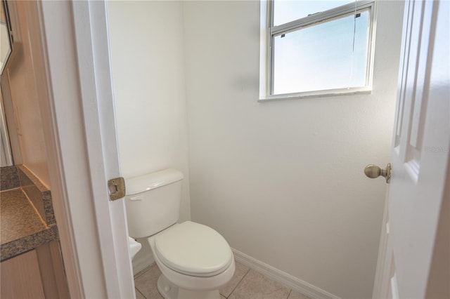 bathroom with toilet, tile patterned flooring, baseboards, and vanity