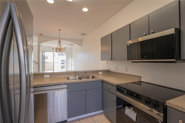 kitchen featuring light tile patterned floors, recessed lighting, a sink, appliances with stainless steel finishes, and decorative light fixtures