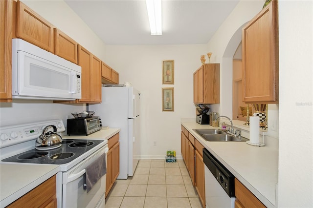 kitchen featuring sink, light tile patterned flooring, and white appliances