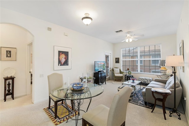 carpeted dining room with ceiling fan