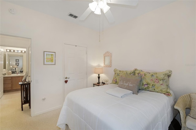 carpeted bedroom with ensuite bath, a closet, and ceiling fan