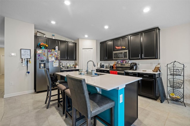 kitchen featuring a kitchen breakfast bar, a kitchen island with sink, appliances with stainless steel finishes, and sink