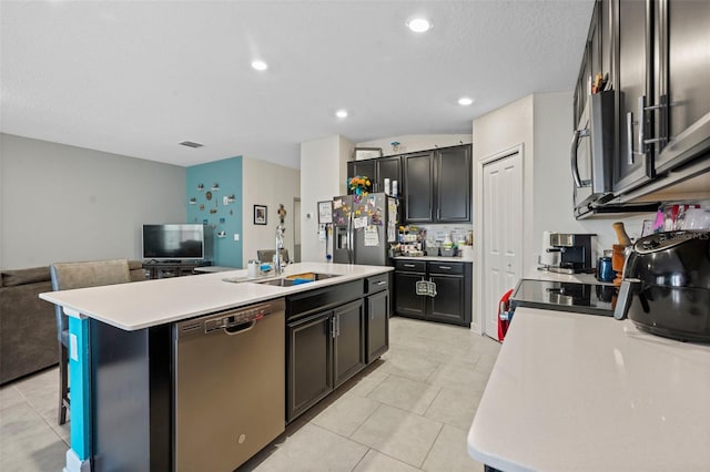 kitchen featuring a center island with sink, stainless steel appliances, sink, and light tile floors