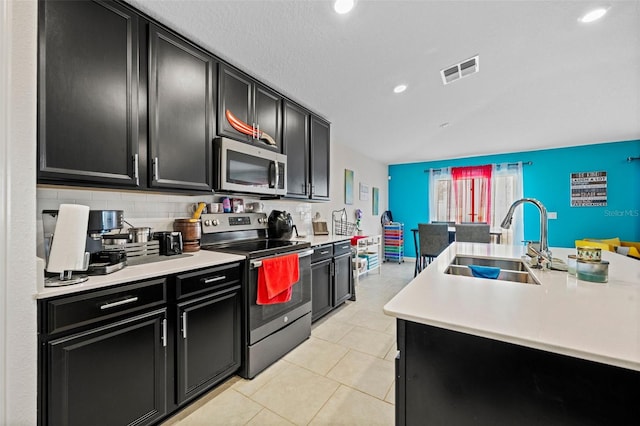 kitchen featuring light tile floors, tasteful backsplash, sink, and stainless steel appliances