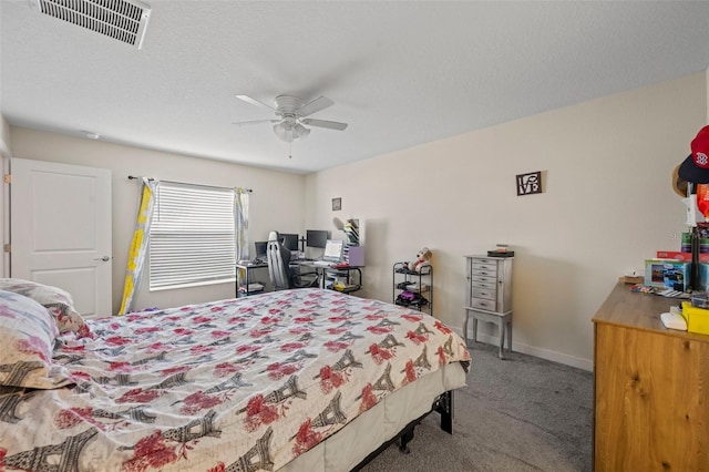 carpeted bedroom featuring ceiling fan and a textured ceiling