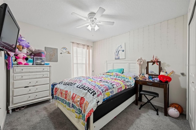 bedroom featuring dark colored carpet, a closet, ceiling fan, and a textured ceiling