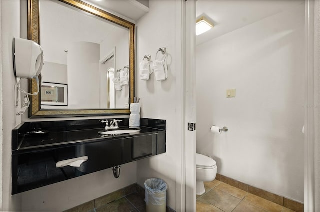 bathroom with sink, tile floors, and toilet