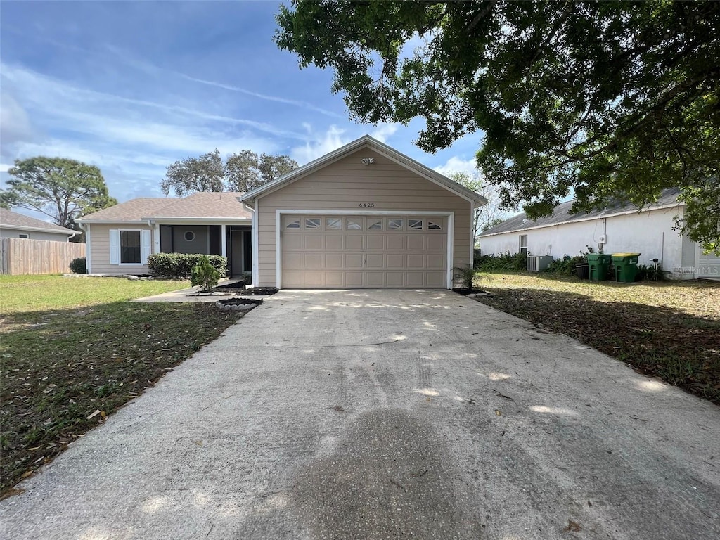 ranch-style home with a front lawn, fence, concrete driveway, a garage, and central AC unit