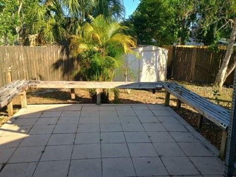 6425 Stillwater Ave, Cocoa, FL 32927 - view of patio with a fenced backyard, an outbuilding, and a storage unit